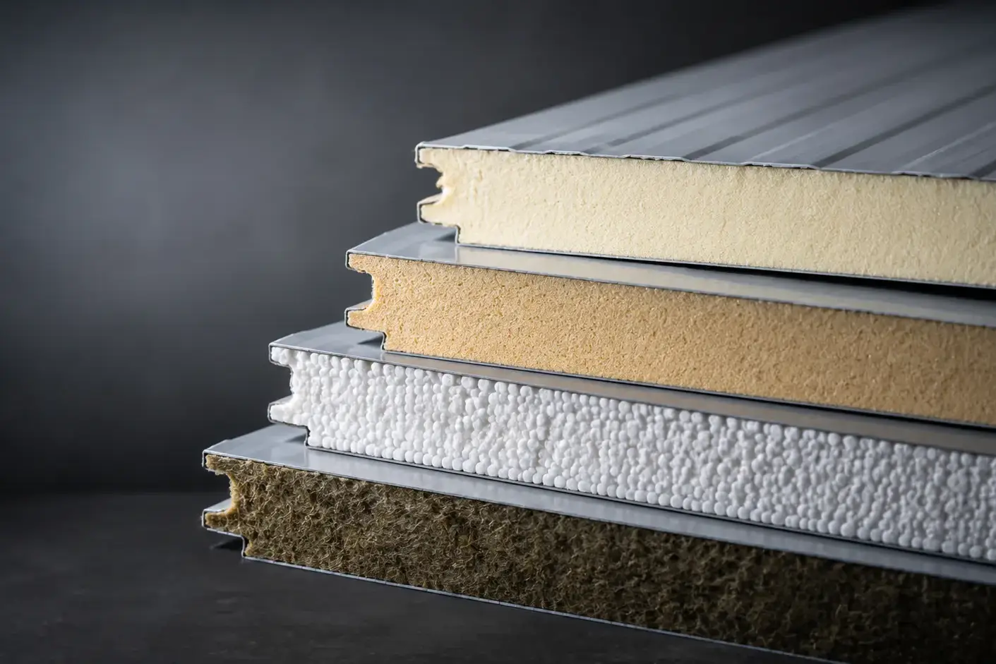Close-up of sandwich panel edges showing PUR, PIR, EPS and rockwool cores between steel facings